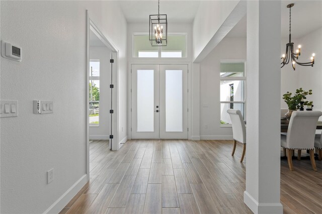 entryway featuring a chandelier, french doors, and light wood-type flooring