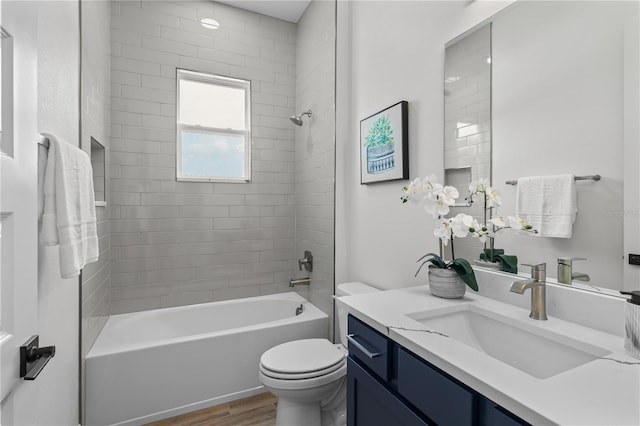 full bathroom featuring vanity, tiled shower / bath, toilet, and hardwood / wood-style floors