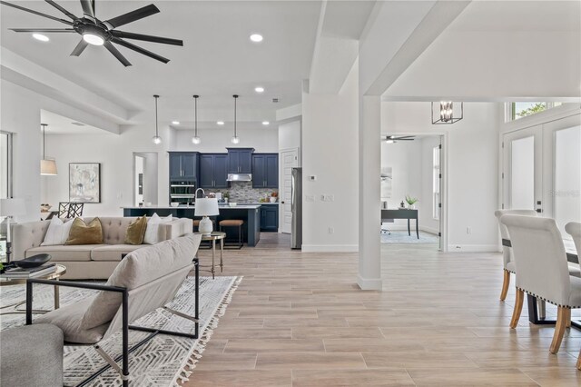 living room featuring ceiling fan with notable chandelier