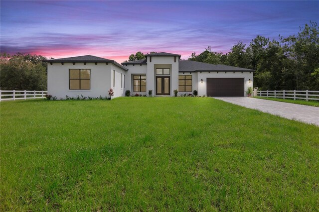 contemporary home featuring a garage and a lawn