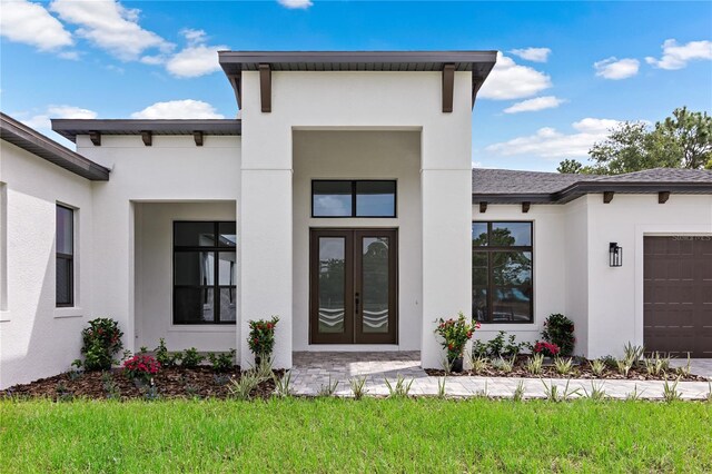 property entrance featuring a garage and french doors