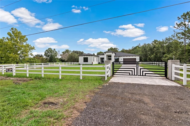 view of front of house featuring a garage, a rural view, and a front yard