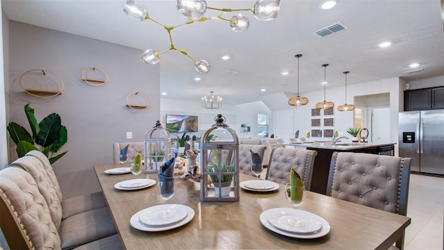 tiled dining room with a chandelier and sink