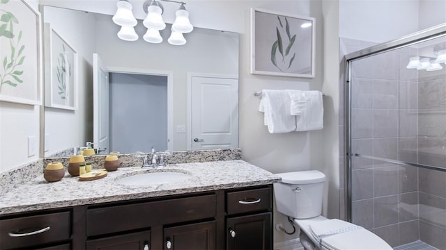 bathroom with toilet, walk in shower, and vanity