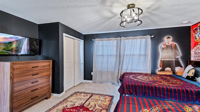 carpeted bedroom with a textured ceiling, a closet, and a notable chandelier