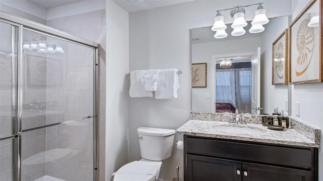 bathroom with toilet, a shower with door, and vanity