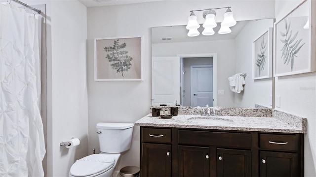 bathroom featuring toilet, vanity, and curtained shower