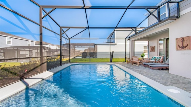 view of swimming pool featuring a lanai and a patio area