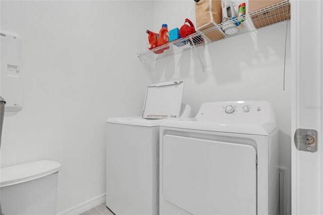 washroom with light tile patterned flooring and washer and clothes dryer