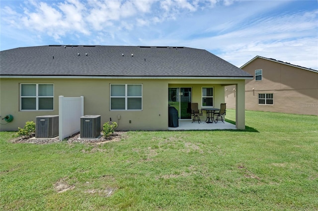 rear view of house featuring central air condition unit, a patio, and a yard