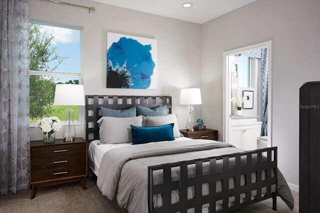 bedroom with ensuite bath and carpet floors