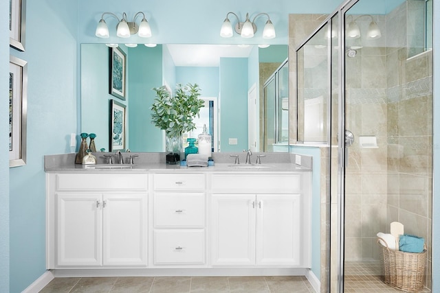 bathroom with a sink, double vanity, a shower stall, and tile patterned flooring