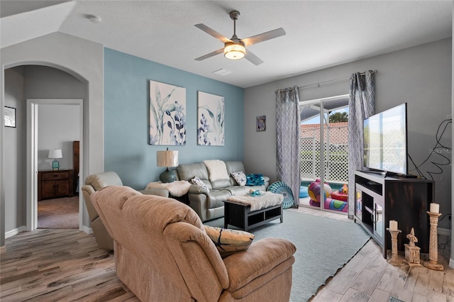 living room featuring lofted ceiling, hardwood / wood-style flooring, and ceiling fan