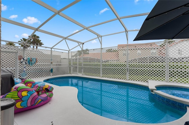 view of swimming pool with an in ground hot tub and a lanai