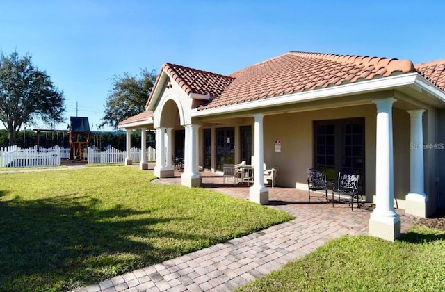 rear view of property with a lawn and a patio area