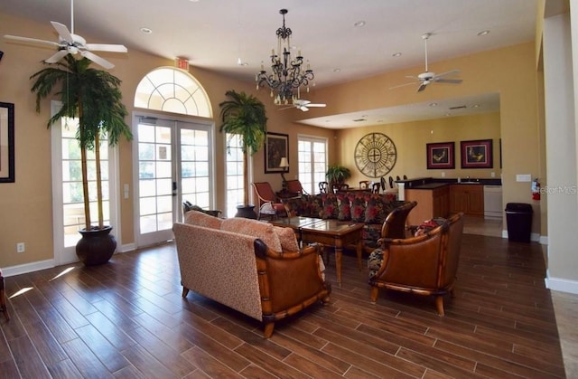 living room featuring french doors and ceiling fan with notable chandelier