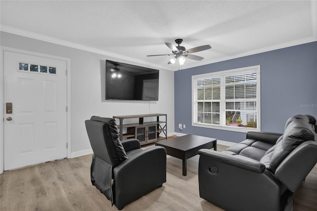 living room featuring ceiling fan, a textured ceiling, light hardwood / wood-style flooring, and ornamental molding