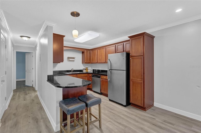 kitchen featuring crown molding, pendant lighting, light hardwood / wood-style flooring, and appliances with stainless steel finishes