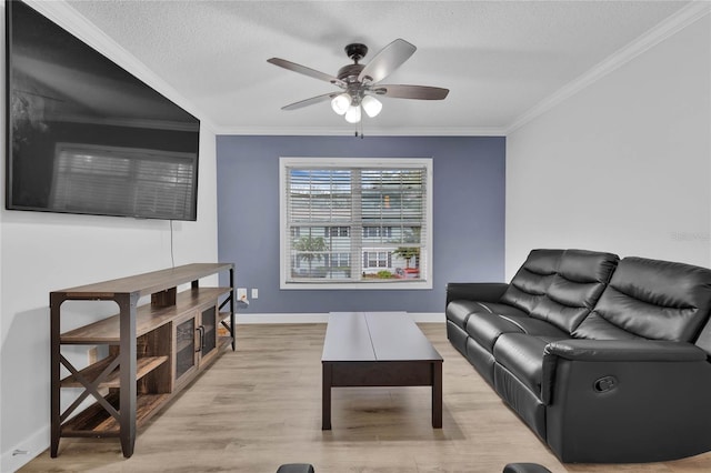 living room with ceiling fan, a textured ceiling, light hardwood / wood-style flooring, and crown molding