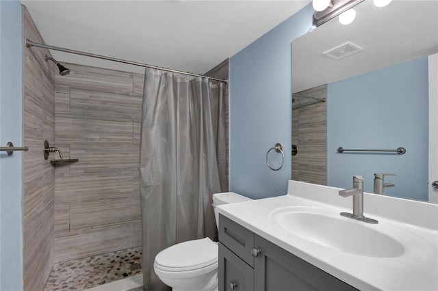 bathroom with curtained shower, toilet, and vanity