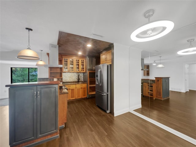 kitchen with stainless steel refrigerator with ice dispenser, a center island, backsplash, and island exhaust hood