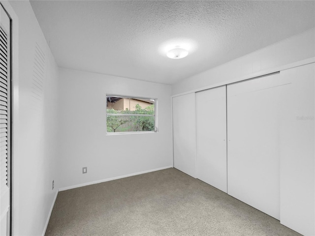 unfurnished bedroom featuring a textured ceiling and a closet