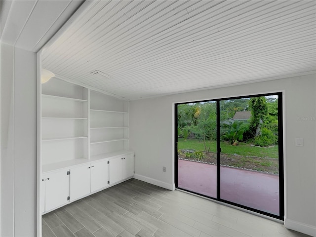 empty room featuring wooden ceiling and light hardwood / wood-style floors