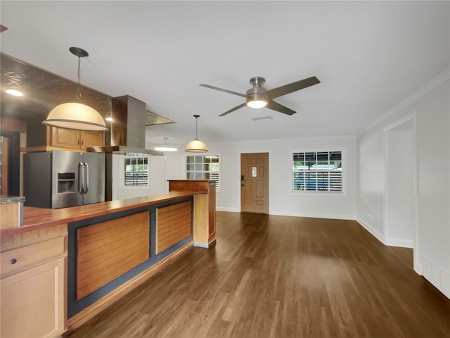 kitchen with island range hood, hanging light fixtures, crown molding, ceiling fan, and stainless steel fridge