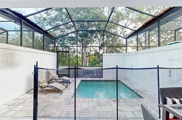 view of swimming pool with glass enclosure and a patio area