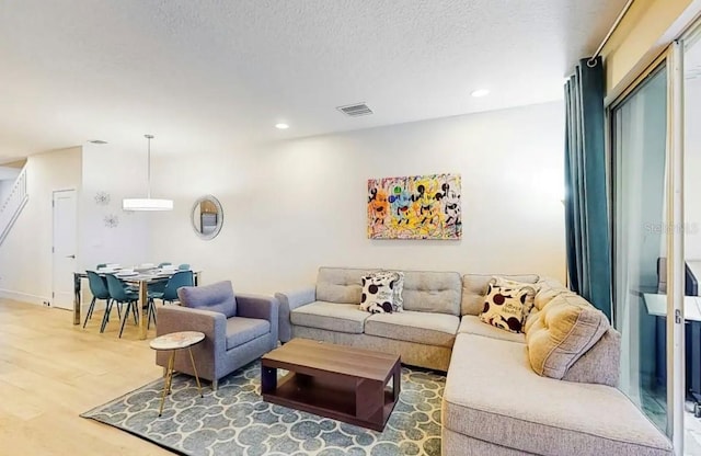 living room with a textured ceiling and hardwood / wood-style floors