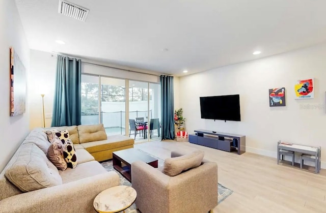 living room featuring a wall of windows and hardwood / wood-style floors