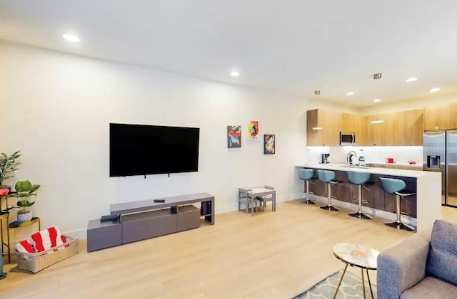 living room featuring light hardwood / wood-style floors and sink