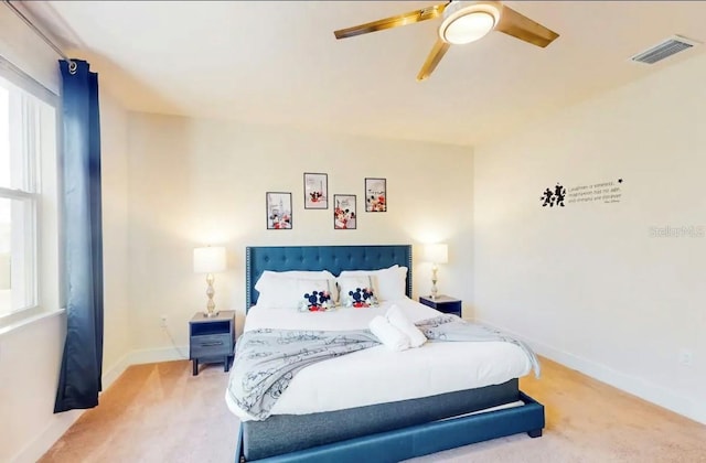 carpeted bedroom with multiple windows and ceiling fan