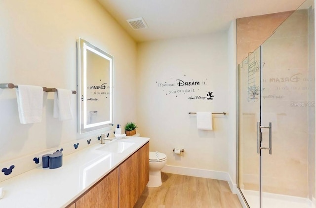 bathroom featuring a shower with shower door, vanity, toilet, and hardwood / wood-style floors