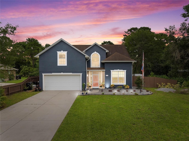 view of front of house featuring a garage and a yard