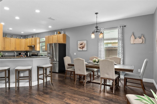 dining room featuring sink, dark wood-type flooring, and a wealth of natural light