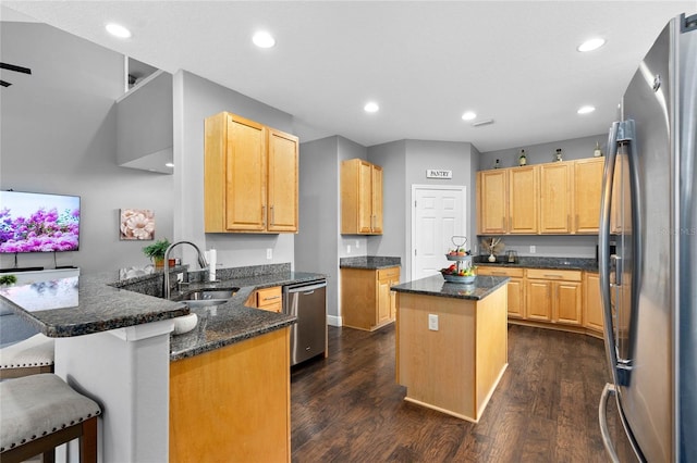 kitchen with a breakfast bar, sink, a center island, kitchen peninsula, and stainless steel appliances