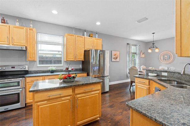 kitchen with sink, decorative light fixtures, a center island, dark stone countertops, and stainless steel appliances