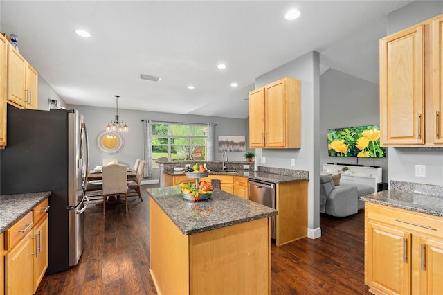 kitchen with sink, a center island, dark hardwood / wood-style floors, pendant lighting, and stainless steel appliances