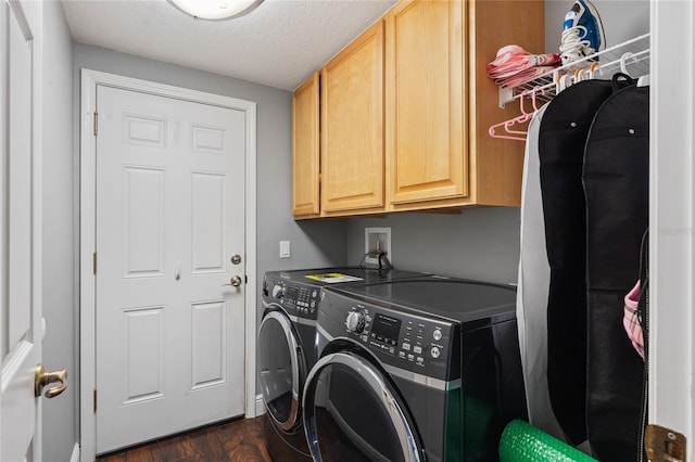 clothes washing area with cabinets, washing machine and clothes dryer, dark hardwood / wood-style floors, and a textured ceiling