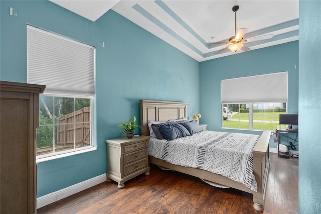 bedroom featuring dark hardwood / wood-style floors, ceiling fan, and a tray ceiling