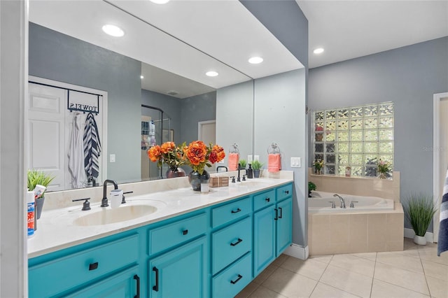 bathroom with vanity, tile patterned flooring, and tiled tub