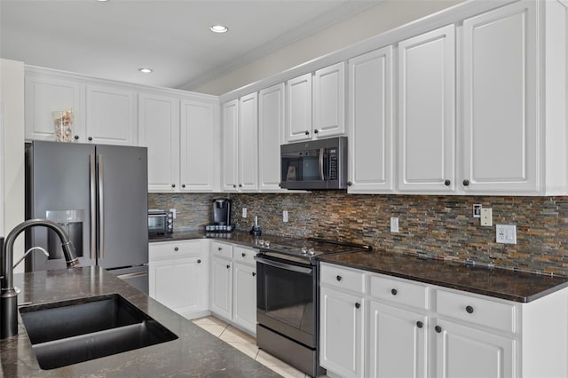 kitchen featuring decorative backsplash, white cabinetry, appliances with stainless steel finishes, light tile patterned flooring, and sink