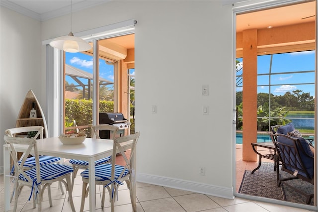 tiled dining area with ornamental molding and a water view