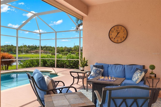 view of patio / terrace featuring glass enclosure and an outdoor fire pit