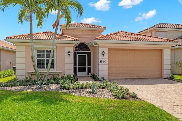 mediterranean / spanish-style house featuring a front yard and a garage