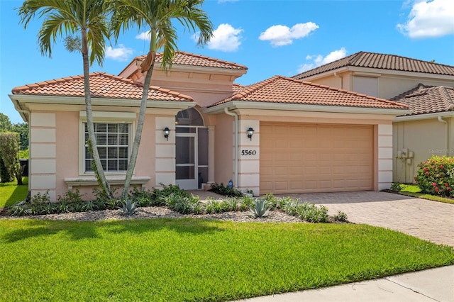 mediterranean / spanish home with a front lawn and a garage