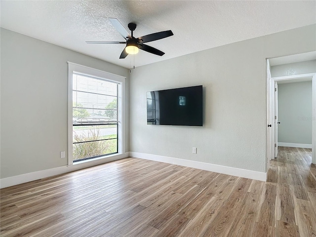 unfurnished living room with ceiling fan, a textured ceiling, and light hardwood / wood-style floors