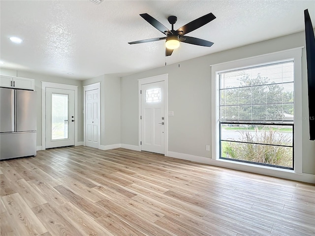 entryway featuring ceiling fan, light hardwood / wood-style flooring, and a textured ceiling