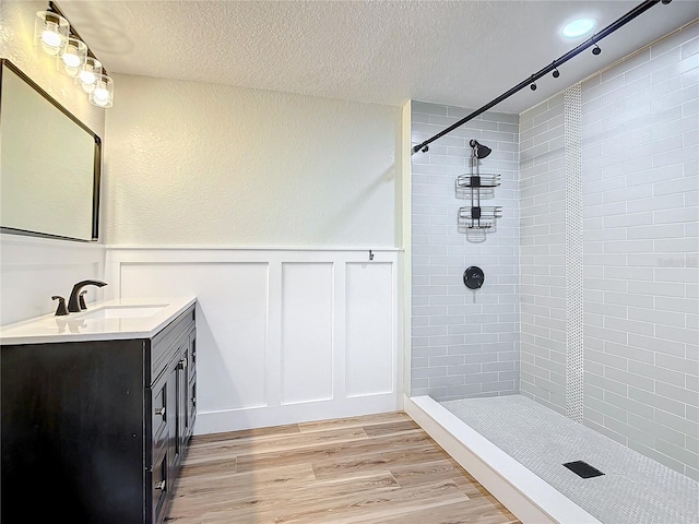 bathroom featuring a tile shower, hardwood / wood-style flooring, and a textured ceiling